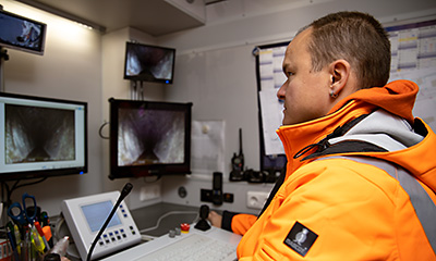Das Bild zeigt einen Mitarbeiter der Stadtentässerung Dresden GmbH, der eine TV-Inspektion in einem Kanal durchführt.