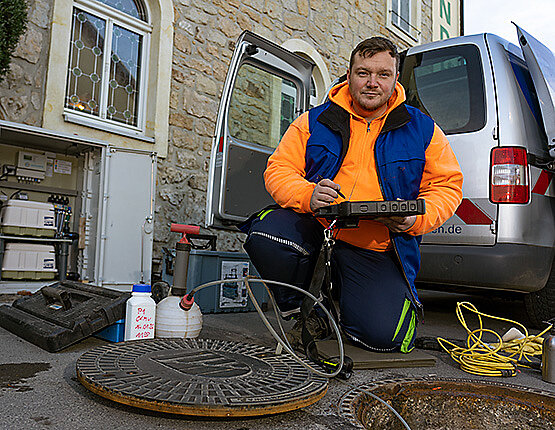 Dieses Bild zeigt einen Mitarbeiter der Stadtentwässerung bei der Wartung einer Kleinkläranlage.