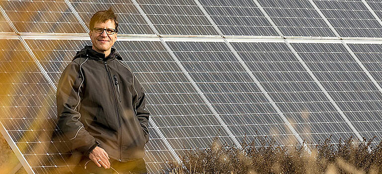 Das Bild zeigt den Leiter des Facility- und Energiemanagements der Stadtentwässerung Dresden GmbH an den Solarpanelen auf der Kläranlage.