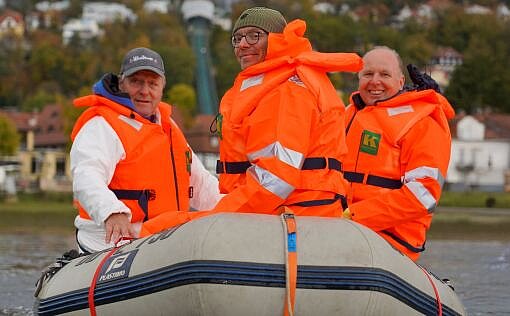 Dieses Bild zeigt die Geschäftsführung und zwei Beschäftigte auf einem Schlauchboot in der Elbe. 