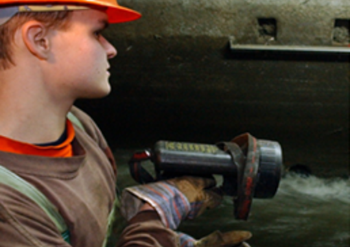 Ein Klärwerker kontrolliert einen Kanal