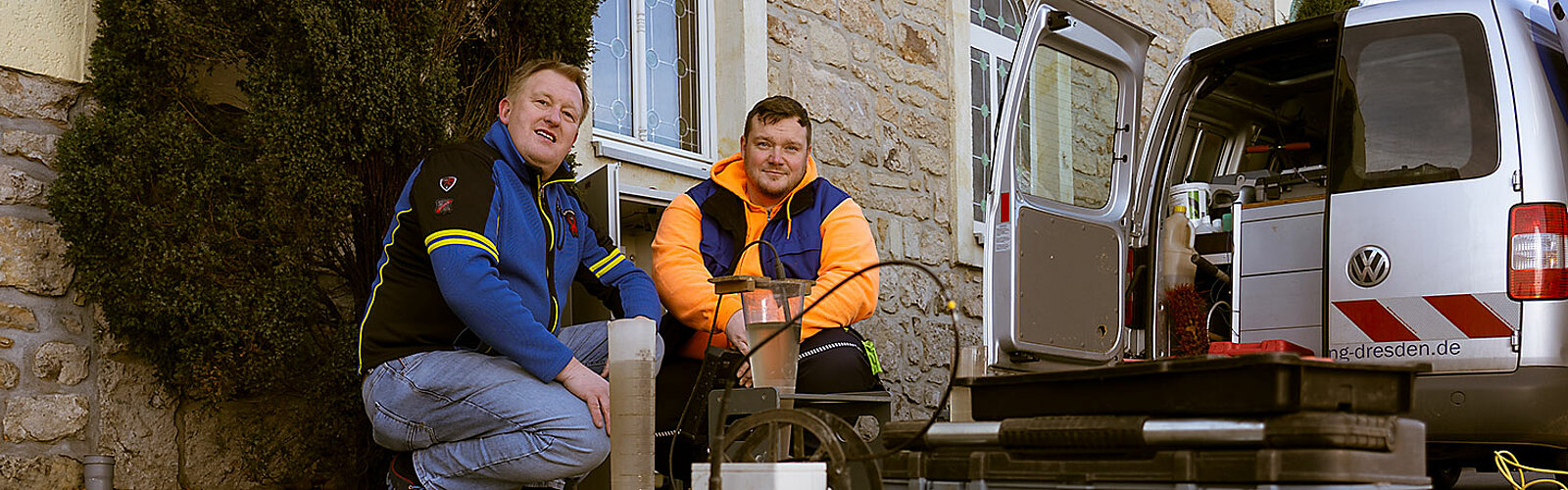 Das Bild zeigt einen Mitarbeiter der Stadtentwässerung Dresden GmbH, der sich um die Kleinkläranlage eines Kunden kümmert.
