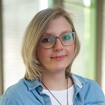 Eine junge Frau lächelt in die Kamera
