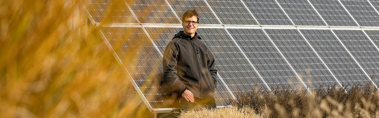 Das Bild zeigt den Leiter des Facility- und Energiemanagements der Stadtentwässerung Dresden GmbH an den Solarpanelen auf der Kläranlage.