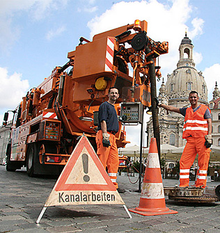 Dieses Bild zeigt einen Mitarbeiter der Stadtentwässerung bei der Kanalreinigung mithilfe eines Spülfahrzeuges auf dem Neumarkt.